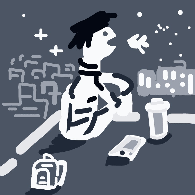 A man is sitting at a table with a cup of coffee and a cell phone.